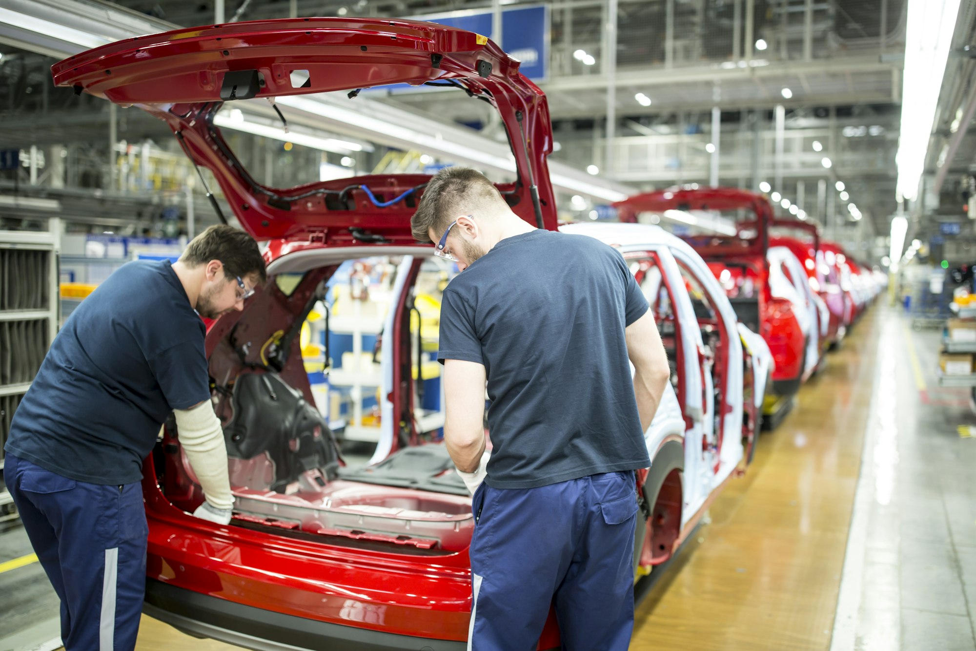 Two colleagues working in modern car factory